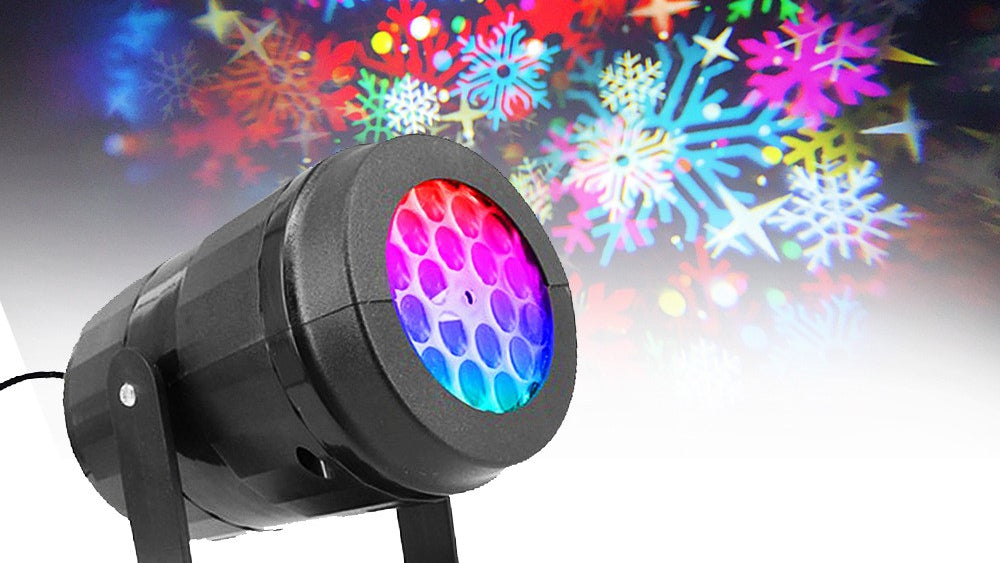 Colorful light projector emitting snowflake patterns on a dark background